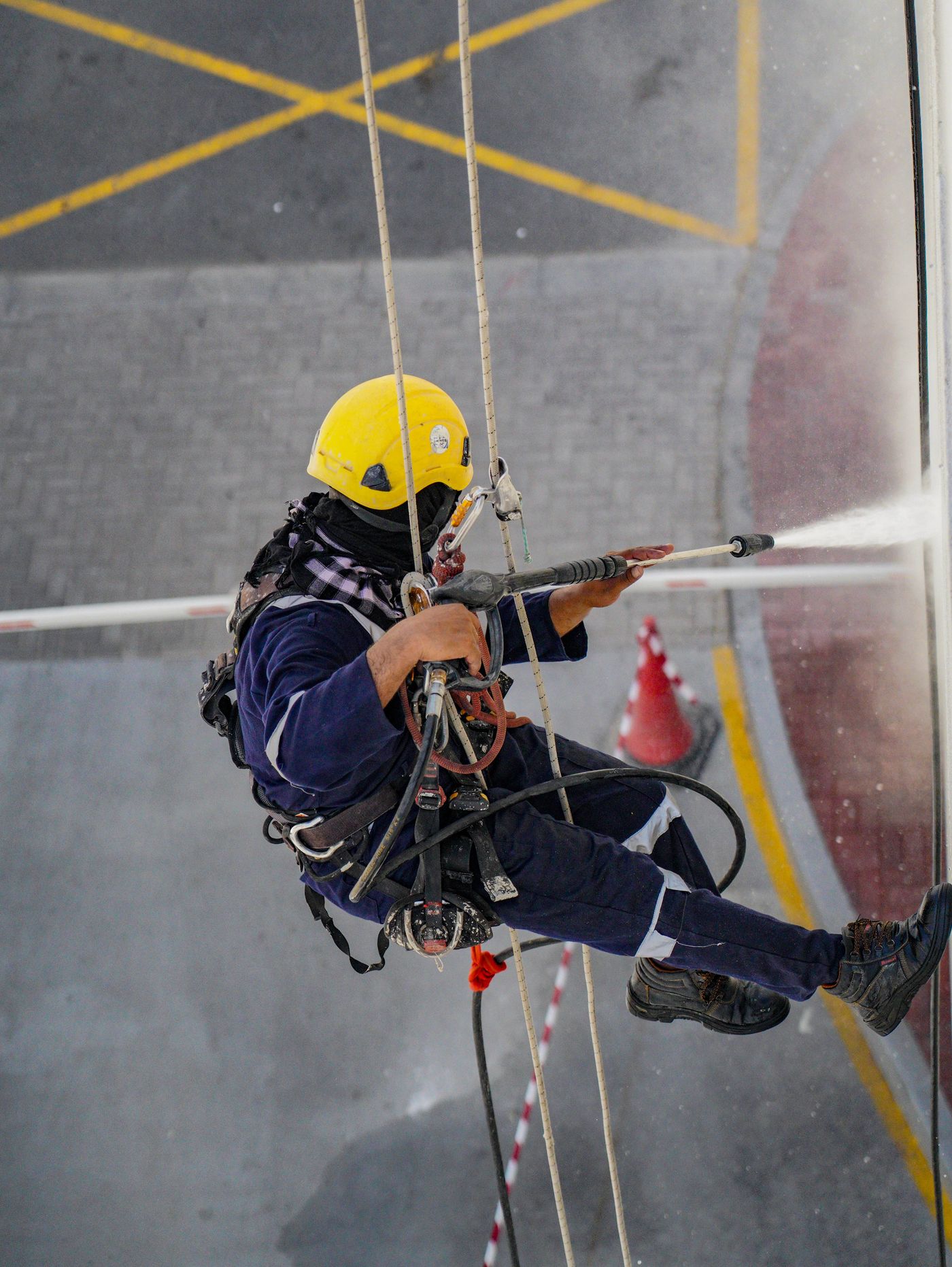 Technician soft washing a building facade