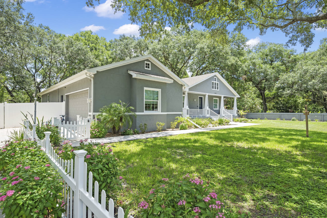 Front exterior photograph of a navy craftsman bungalow listing in Tampa Florida